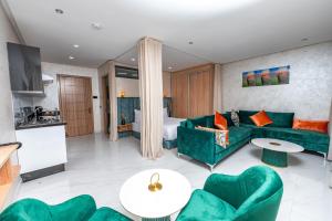 a living room with a green couch and chairs at Maarif elite suites in Casablanca