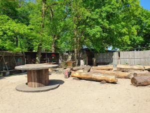 a picnic table and logs in a zoo at Tipidorf Walbeck in Geldern