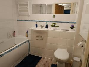 a bathroom with a toilet and a sink and a tub at Stylish 2BD near Gatwick Airport in Crawley in Crawley