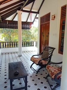 a porch with two chairs and a table and a table at Rock Pool Residence in Tangalle