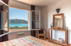 a bedroom with a large window with a view of the ocean at Résidence Les Hameaux de Santa Giulia in Porto-Vecchio