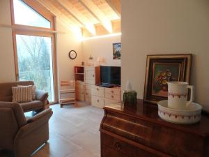 ein Wohnzimmer mit einem Sofa und einem TV in der Unterkunft Apartment Studentenweg 33 by Interhome in Engelberg
