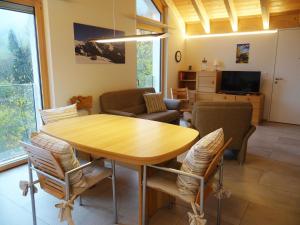 uma sala de estar com uma mesa de madeira e cadeiras em Apartment Studentenweg 33 by Interhome em Engelberg
