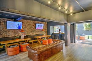 a restaurant with a leather couch and a table and a person at Never at Home Green Point in Cape Town +23 photos