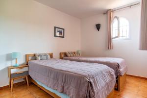 a bedroom with two beds and a window at Résidence Les Hameaux de Santa Giulia in Porto-Vecchio