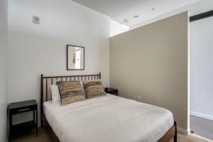 1 dormitorio con 1 cama blanca y 2 almohadas en Downtown studio w gym wd nr waterfront BOS-985, en Boston