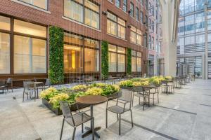uma fila de mesas e cadeiras num edifício com plantas em Downtown studio w gym wd nr waterfront BOS-985 em Boston