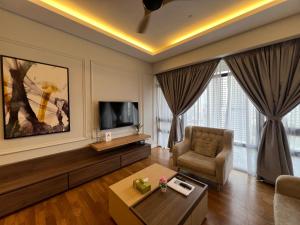 a living room with a tv and a couch and a chair at Anggun KL MY in Kuala Lumpur