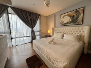 a bedroom with a white bed with a large window at Anggun KL MY in Kuala Lumpur +82 photos