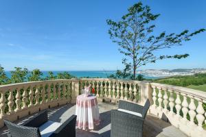 una mesa y sillas en un balcón con vistas al océano en Italian Experience- Villa Krizia en Ancona