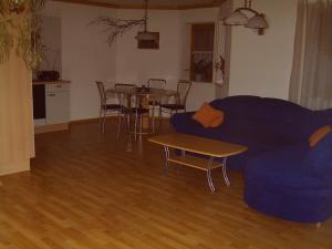 ein Wohnzimmer mit einem blauen Sofa und einem Tisch in der Unterkunft Ferienwohnung Reisinger in Arnbruck