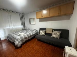 - une petite chambre avec un lit et un canapé dans l'établissement Apartamento con vistas al mar y piscina II, à Suances