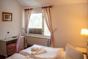 una camera da letto con un letto, una finestra e una scrivania di Meeressterne Hotel Weißes Schloß a Heringsdorf Altre 51 foto