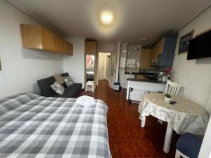 Cette chambre comprend un lit, une table et une cuisine. dans l'établissement Apartamento con vistas al mar y piscina II, à Suances