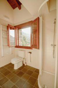 a bathroom with a toilet and a window and a shower at Casa Rural Ger in Yeste