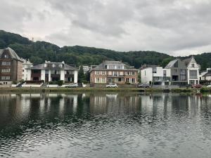 a group of houses next to a body of water at La Pairelle in Namur