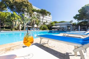 a swimming pool with a table and a bench at Abamar Hotel in Santa Margherita di Pula