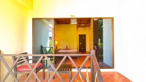 Villa Bali Eco Resort, Rayong في رايونغ: شرفة منزل مع طاولة وكراسي
