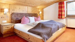 een slaapkamer met een bed met een deken erop bij Appartements Alpenrose in Längenfeld