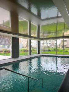 - une grande piscine dans un bâtiment doté de fenêtres dans l'établissement Domitys Calandra, à Villepinte