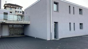ein weißes Gebäude mit einem Balkon an der Seite in der Unterkunft Grand appartement proche de Délemont avec terrasse by Stay Swiss 