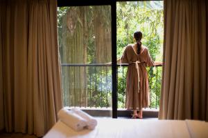 a woman in a dress looking out of a window at Etereo Stays, Luxury Premium Apartments, Arpora, Goa in Arpora