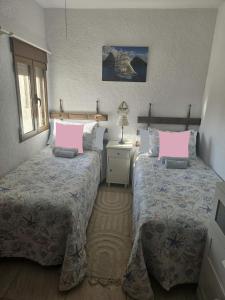 1 dormitorio con 2 camas y almohadas rosas en Villa Adriana v rezidencii Toscamar, en Jávea
