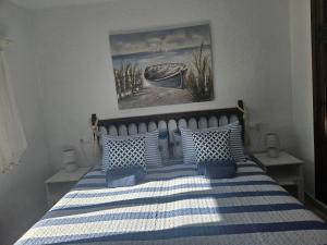 Cama con sábanas y almohadas de rayas azules y blancas en Villa Adriana v rezidencii Toscamar, en Jávea