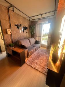 a living room with a couch and a map on the wall at Apartamento Centro Venâncio Aires in Venâncio Aires