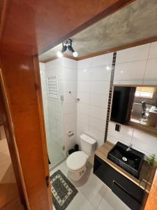 a small bathroom with a toilet and a television at Apartamento Centro Venâncio Aires in Venâncio Aires