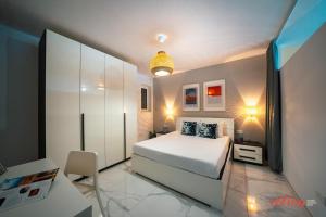 um quarto com uma cama branca e um armário em A Stylishly Chic Holiday Home with SOFA BED - A12 em St. Paul's Bay