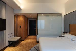 um quarto com uma cama branca e uma grande janela em Sheraton Mall of the Emirates Hotel, Dubai em Dubai