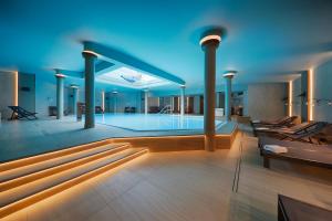 a swimming pool in a building with blue lighting at Schloßappartements Heringsdorf in Heringsdorf