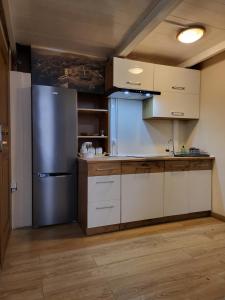a kitchen with a stainless steel refrigerator and white cabinets at AMBER APARTAMENt #10 in Krakow