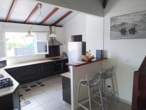 a kitchen with black cabinets and a white refrigerator at Villa Akaz in Le Robert