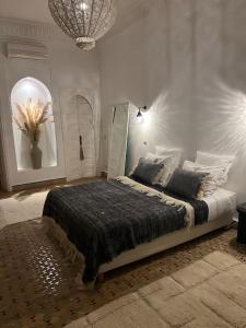 - une chambre avec un lit et un lustre dans l'établissement Villa Nejma, à Marrakech