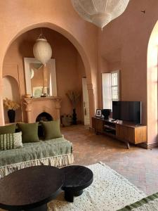 - un salon avec un canapé et une télévision dans l'établissement Villa Nejma, à Marrakech