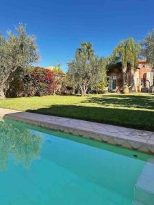 - une piscine en face d'une cour avec une maison dans l'établissement Villa Nejma, à Marrakech
