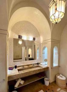 La salle de bains est pourvue d'un grand miroir et d'un lavabo. dans l'établissement Villa Nejma, à Marrakech