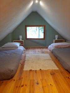 Pokój na poddaszu z 2 łóżkami i oknem w obiekcie Domek letni Konopka w mieście Jeżów Sudecki