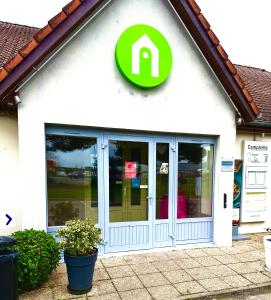 a store front with a green sign on it at Campanile Marmande in Marmande