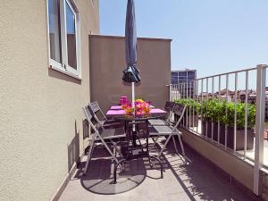 a patio table with chairs and an umbrella on a balcony at Charmsuites Nou Rambla in Barcelona