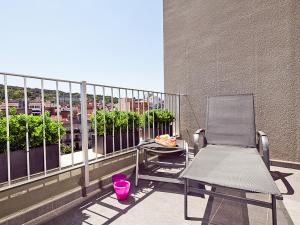 a balcony with a chair and a table on a balcony at Charmsuites Nou Rambla in Barcelona