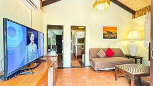 Villa Bali Eco Resort, Rayong في رايونغ: غرفة معيشة مع تلفزيون بشاشة مسطحة كبيرة