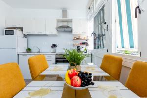 El Drago Apartment Fiber ,A/C,Near Ocean في طوستا ديل سيلونثيو: مطبخ مع طاولة عليها صحن من الفواكه