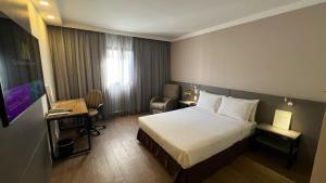 um quarto de hotel com uma cama e uma cadeira em Intercity São Paulo Berrini em São Paulo
