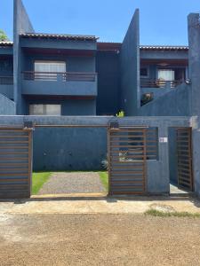 uma casa com dois portões em frente a um edifício em Casa de férias Itacare em Itacaré