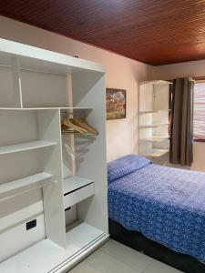 um quarto com uma cama e prateleiras brancas em Casa de férias Itacare em Itacaré