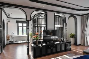 a living room with black and white walls and a flat screen tv at Thiên Ân Boutique Hotel in Bạc Liêu