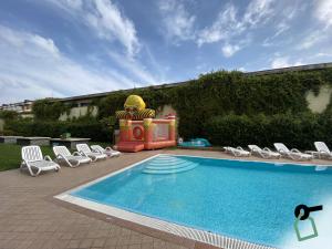 a swimming pool with chairs and a inflatabletheme at HOTIDAY Residence Garda in Peschiera del Garda